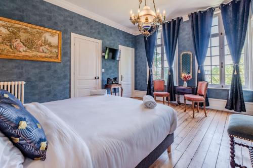 a bedroom with a large bed and blue walls at Le Manoir de la belle epoque in Béthencourt-sur-Mer