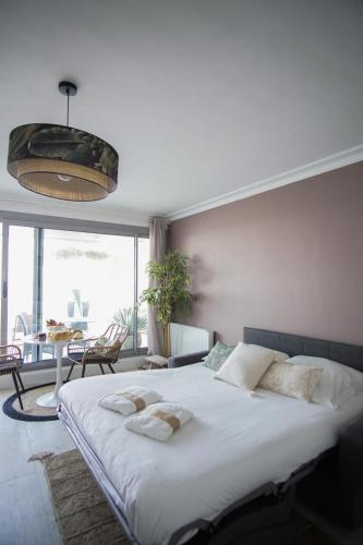 une chambre avec un grand lit avec deux serviettes dessus dans l'établissement -SUNSET- Front de mer avec terrasse et parking, à Concarneau