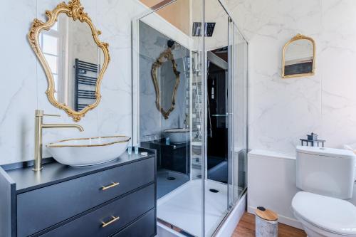 a bathroom with a glass shower and a sink at Le Manoir de la belle epoque in Béthencourt-sur-Mer