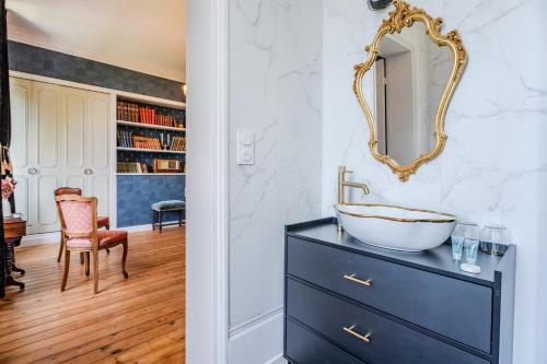 a bathroom with a sink and a mirror on a dresser at Le Manoir de la belle epoque in Béthencourt-sur-Mer