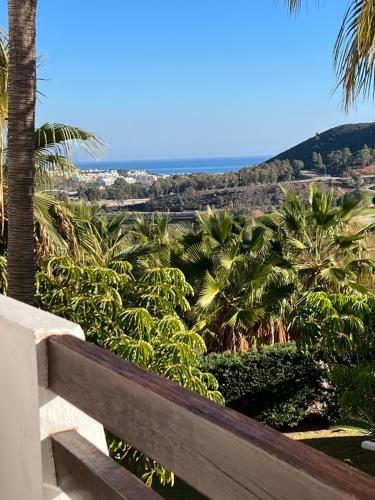 a view from the balcony of a resort with palm trees at Modern Sea & Golf View 2-Bedroom Apartment with Pool and Terrace in Calanova in Mijas