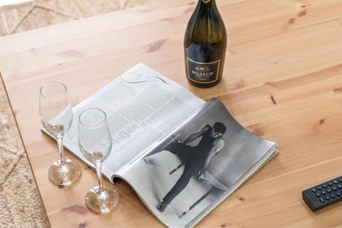 a magazine on a table with a bottle of wine and two glasses at Perfect Contractor Stay - Sleeps 6 - FREE Parking in Sheldon