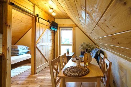 a dining room with a table in a cabin at Apartament z widokiem na Jezioro Solińskie - Zawóz in Zawóz