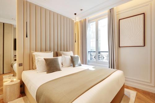 une chambre avec un grand lit et une fenêtre dans l'établissement TheLander - Serviced Apartment in Le Marais, à Paris