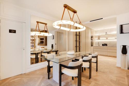 une cuisine et une salle à manger avec une table et des chaises dans l'établissement TheLander - Serviced Apartment in Le Marais, à Paris