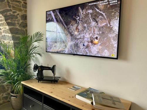a flat screen tv hanging on a wall with a sewing machine at Apartamentos BuenaVista in Colunga