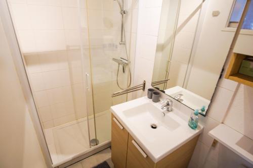 une salle de bain avec un lavabo et une douche dans l'établissement -UGO- T1 bis avec parking proche plage, à Concarneau