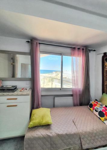 - une petite chambre avec un lit et une fenêtre dans l'établissement One bedroom apartement with sea view shared pool and balcony at Hergla, à Harqalah