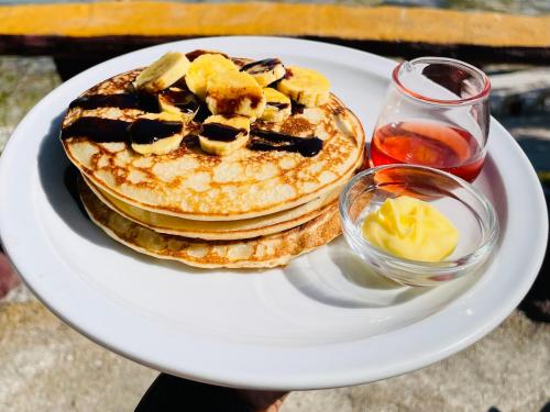 a plate with a stack of pancakes with fruit on it at La Concepcion Cove Garden Resort in Moalboal