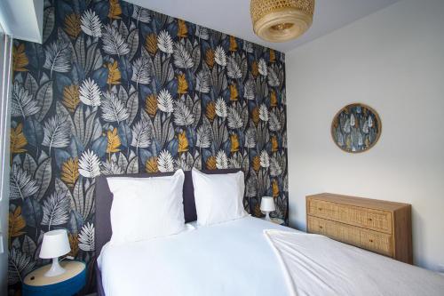 une chambre avec un lit avec un papier peint fleuri dans l'établissement -IRIS- Magnifique T2 renove avec balcon et parking, à Concarneau