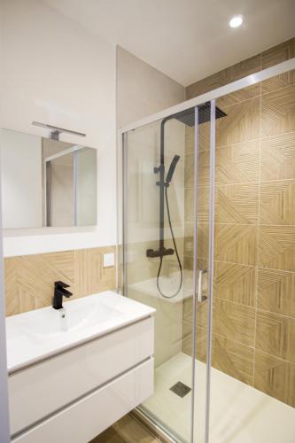 une salle de bain avec un lavabo blanc et une douche dans l'établissement -IRIS- Magnifique T2 renove avec balcon et parking, à Concarneau