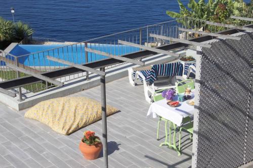 a balcony with a table and chairs and the water at Irlandas Villa Funchal Seaside Villas in Funchal