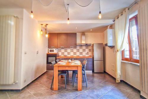 a kitchen with a wooden table and chairs in it at Sweet Home in Serravalle Sesia