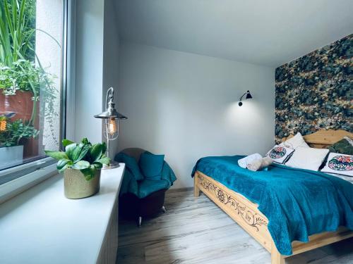a bedroom with a bed and a chair and a window at Zakątek Słoneczny pod Baranią Górą in Kamesznica