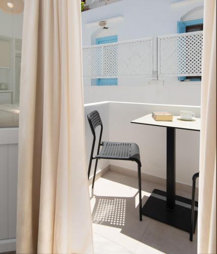 a table and chair in a kitchen with a curtain at Porte Accommodation in Kamarai