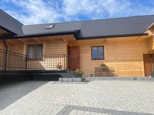 a wooden house with a porch and a balcony at Apartament u Teresy in Harkabuz