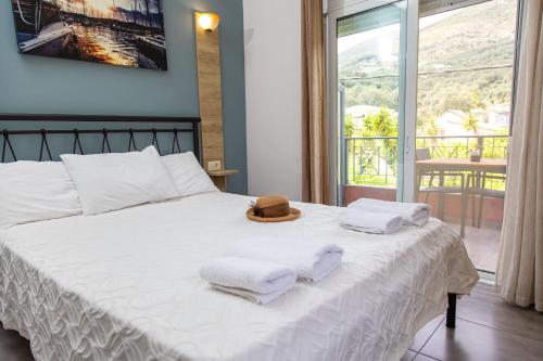 ein Bett mit Handtüchern und einem Hut darüber in der Unterkunft Aurora Premium Hospitality in Parga