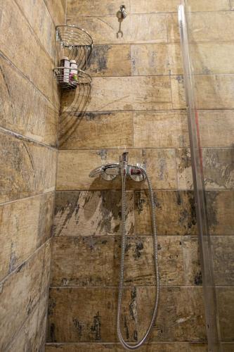 a bathroom with a shower with a wooden wall at Aurora Premium Hospitality in Parga