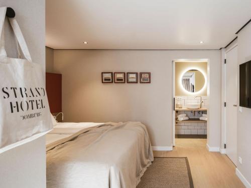 a bedroom with a bed and a mirror at Strandhotel Domburg - Next Door in Domburg