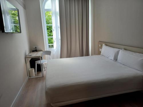 フィゲイラ・ダ・フォズにあるB&B HOTEL Figueira Da Fozのベッドルーム(白いベッド1台、窓付)