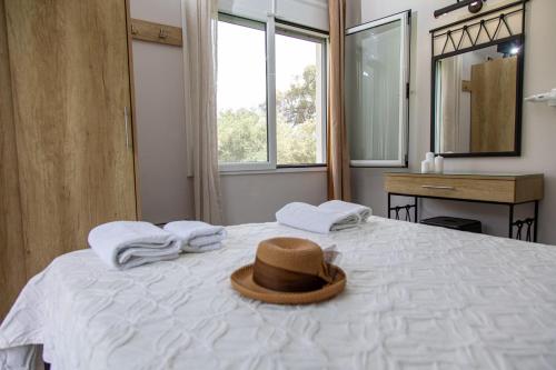 a hat sitting on top of a bed with towels at Aurora Premium Hospitality in Parga