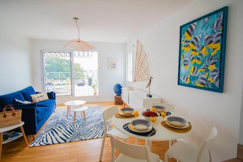un salon avec une table et un canapé bleu dans l'établissement -La Terrasse- T2 avec Terrasse vue mer, à Concarneau