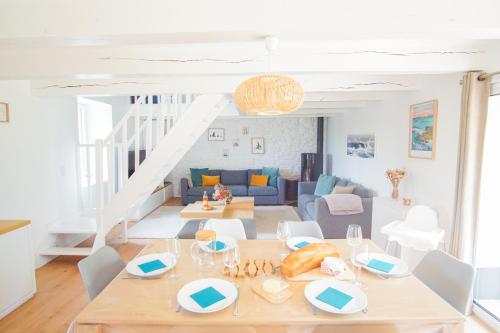 une salle à manger et un salon avec une table et des chaises dans l'établissement -PETREL- Maison de campagne avec grand jardin, à Concarneau