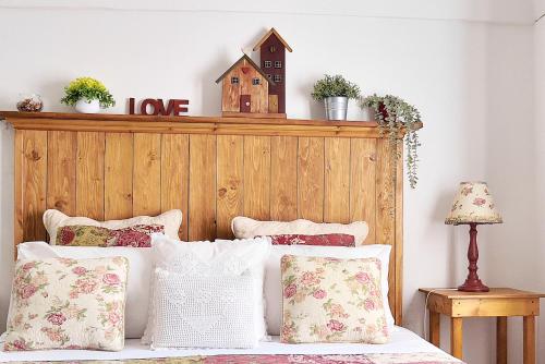 a bedroom with a bed with a wooden headboard and pillows at Case del Vicolo Stretto in Modica