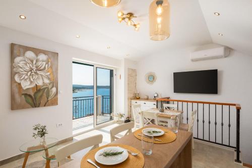 una sala da pranzo con un tavolo e una televisione di Bobel Deluxe Tiny House a Povlja