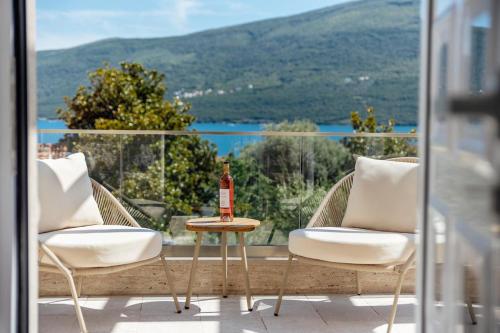 a bottle of wine sitting on a table on a balcony at Bella Vista Luxure Apartments in Baošići
