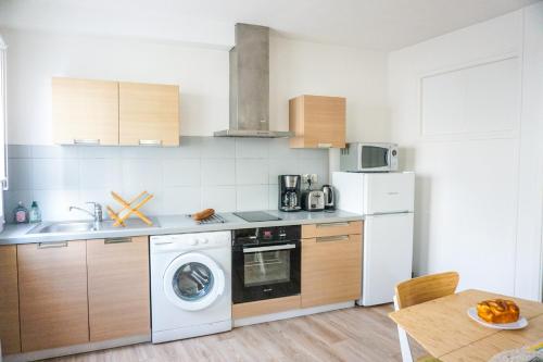 une cuisine avec un lave-linge et un lave-vaisselle dans l'établissement -ZOEY- Beau T1 bis avec parking, à Concarneau