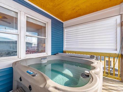 a jacuzzi tub in a blue room with windows at Sea Chase in Topsail Beach