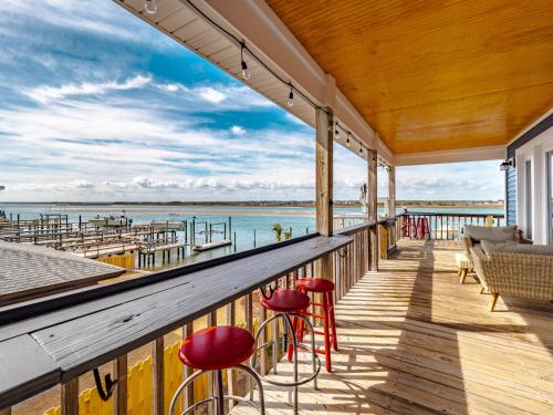 a balcony with red stools and a view of the water at Sea Chase in Topsail Beach