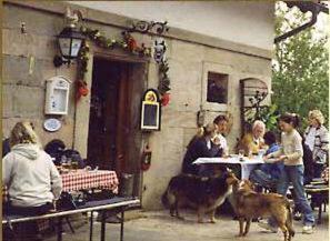 a group of people sitting at a table with two dogs at Landhotel Schwärzhof in Kulmbach