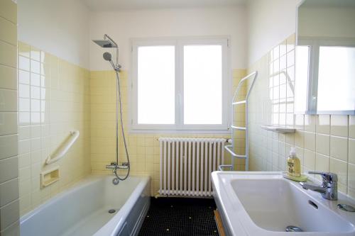 a bathroom with a tub and a sink and a window at -ERNEST-Maison avec jardin a 200m des plages in Concarneau