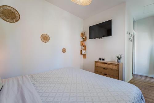 a bedroom with a bed and a tv on the wall at Le Manoir de la belle epoque in Béthencourt-sur-Mer