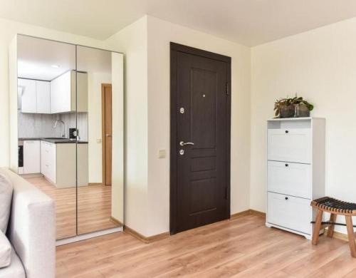 a living room with a brown door and a kitchen at Tolumoje Marios poilsis Nidoje in Nida