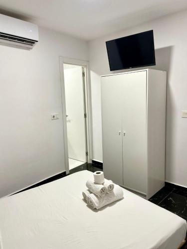 a bedroom with a bed with a towel and a tv at SL Marbella in Marbella