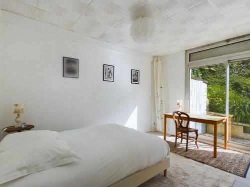 une chambre avec un lit, un bureau et une fenêtre dans l'établissement -Palerme- Spacieux appartement proche bord de mer, à Concarneau