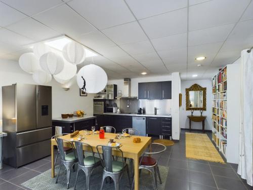 une cuisine avec une table et des chaises dans une pièce dans l'établissement -Palerme- Spacieux appartement proche bord de mer, à Concarneau