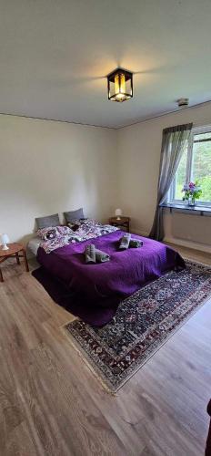a bedroom with a purple bed and a window at Hammarstrandvilla in Hammarstrand