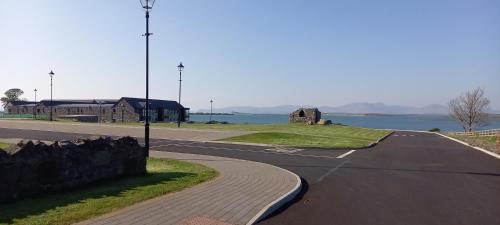 an empty street with a road next to the water at Murrisk Apartments - Self Catering in Westport
