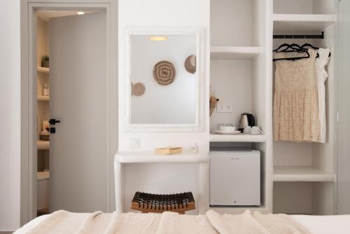 a bedroom with a bed and white walls and shelves at Porte Accommodation in Kamarai