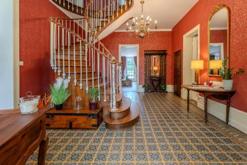 a living room with a spiral staircase and orange walls at Le Manoir de la belle epoque in Béthencourt-sur-Mer