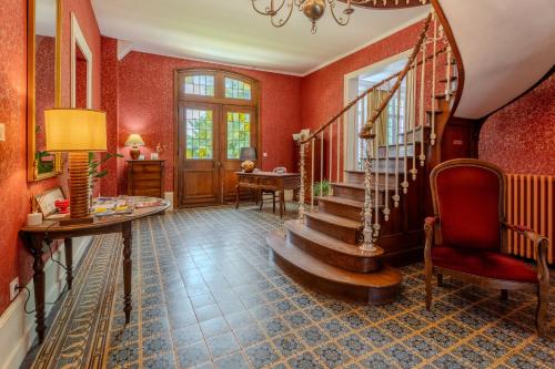 a staircase in a room with red walls at Le Manoir de la belle epoque in Béthencourt-sur-Mer