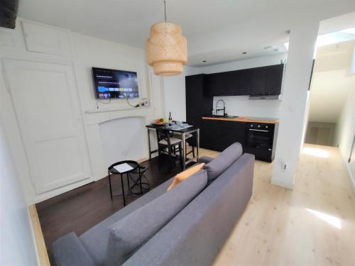 un salon avec un canapé bleu et une table dans l'établissement Appartement EMILiA Centre ville, à Vitré