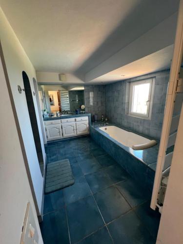 une grande salle de bain avec une baignoire et un lavabo dans l'établissement Villa Vue Mer Exceptionnelle 5 Chambres, à Sainte-Maxime
