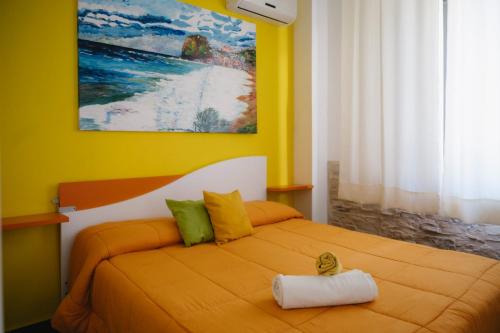 a yellow bedroom with a bed with a towel on it at Stop And Go in Scilla