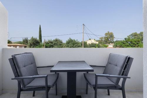 two chairs and a table on a balcony at Ilios Properties - next to Gouvia Beach in Gouvia