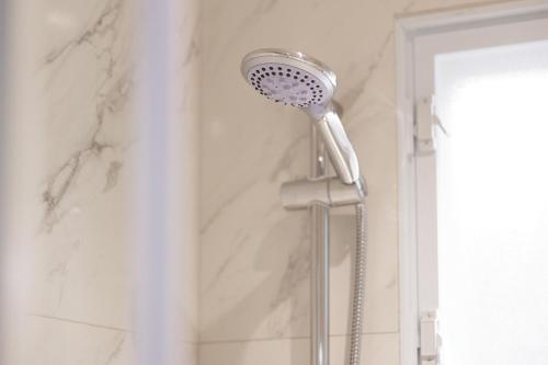 a shower in a bathroom with a shower head at Ilios Properties - next to Gouvia Beach in Gouvia